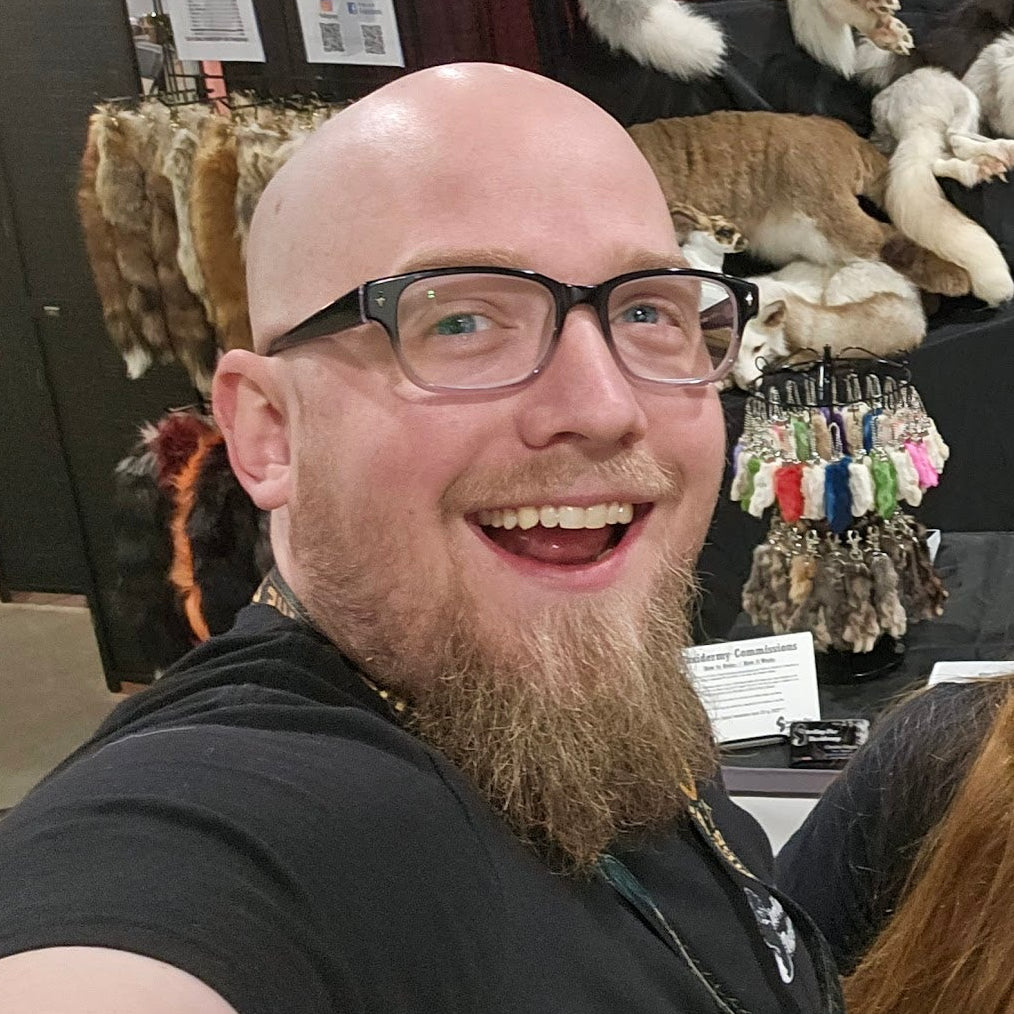 Man with beard in front of taxidermy booth.